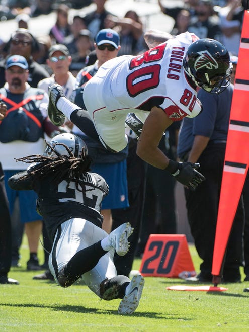 Raiders defender Reggie Nelson (27) upends Falcons tight end Levine Toilolo (80) after a first-half catch.