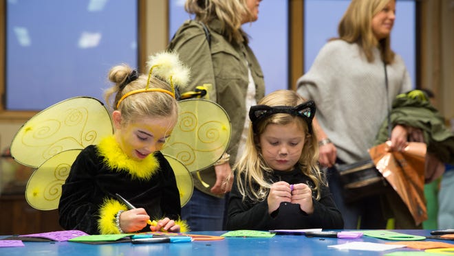 Ryley Fox, 4, (left) and Katie Gugat, 4, both of Johnston, make crafts Friday, Oct. 23, 2015, during Halloween Hoopla at Raccoon River Park in West Des Moines.