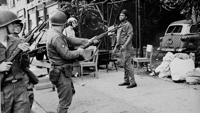 An African American man being confronted and frisked by police in Detroit during the riots in 1967.