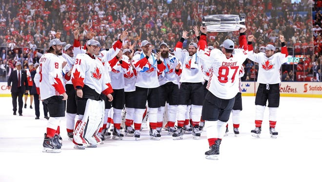 Sidney Crosby (87) passes the championship trophy to his teammates after Canada won the World Cup of Hockey.