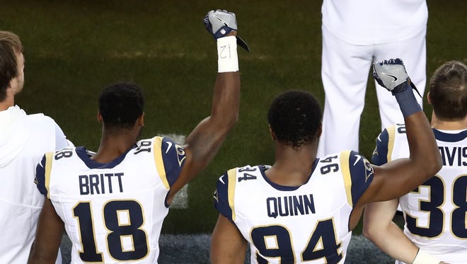 Kenny Britt (18) and Robert Quinn (94) of the Rams raised their fists in protest during the national anthem before the season opener against Colin Kaepernick and the 49ers.