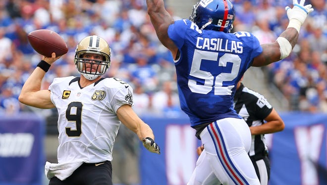 New Orleans Saints quarterback Drew Brees (9) runs out of the pocket to avoid New York Giants outside linebacker Jonathan Casillas (52) during the first half at MetLife Stadium.