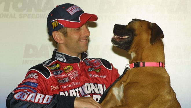Greg Biffle, left, smiles at his pet boxer Gracie in 2005 during a news conference  at Daytona International Speedway.