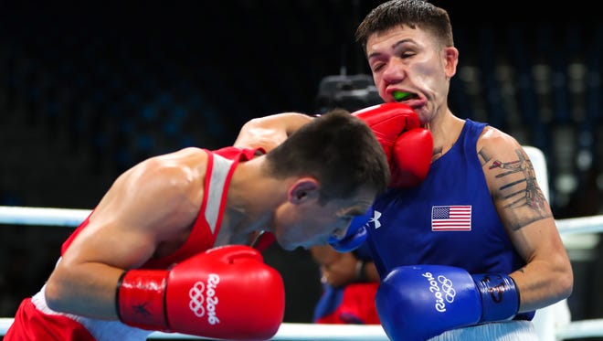 Nico Miguel Hernandez of the United States takes a punch from Hasanboy Dusmatov Uzbekistan during men's light fly competition in the Rio 2016 Summer Olympic Games at Riocentro - Pavilion 6.