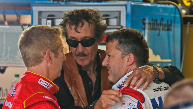 Richard Petty, center, hugs Tony Stewart as they talk to Greg Biffle, left, in the garage at Richmond International Raceway on April 22, 2016.