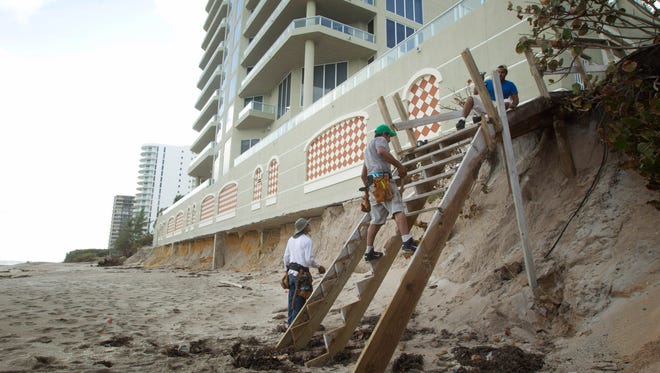 Construction workers at Ocean Edge condo on Singer Island, Fla., rebuild a walk to the beach on Nov. 29, 2012, after Superstorm Sandy and heavy waves washed away the sand from under the building.