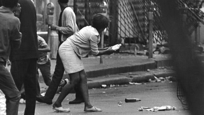 A woman prepares to throw a bottle during the riots in Detroit in1967.