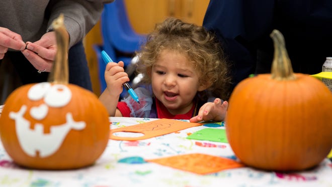 Callie Paquette, 2, of West Des Moines, makes crafts Friday, Oct. 23, 2015, during Halloween Hoopla at Raccoon River Park in West Des Moines.
