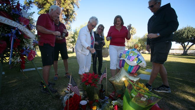A group of friends and Frank Sinatra fans from Indio toast Sinatra at his grave on his 100th birthday on Saturday at the Desert Memorial Park in Cathedral City.