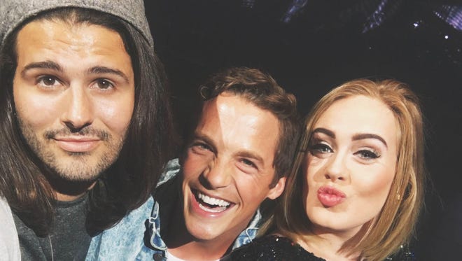Vince Rossi and Ryan Salonen pose for a selfie on stage at the Los Angeles Staples Center with Adele during her concert.