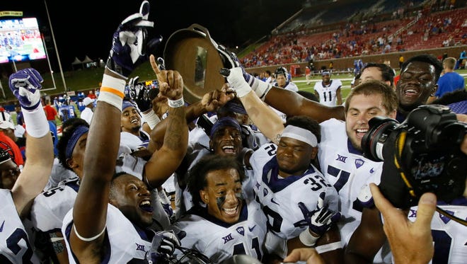 TCU players celebrate with the Iron Skillet after beating Southern Methodist.