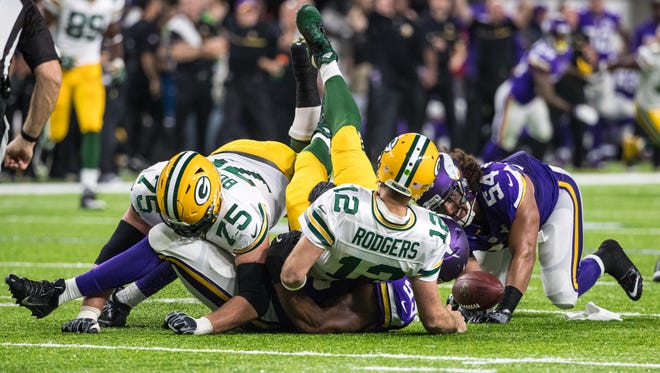 Green Bay Packers quarterback Aaron Rodgers (12) is sacked by Minnesota Vikings linebacker Eric Kendricks (54) and defensive end Danielle Hunter (99) during the first quarter at U.S. Bank Stadium.