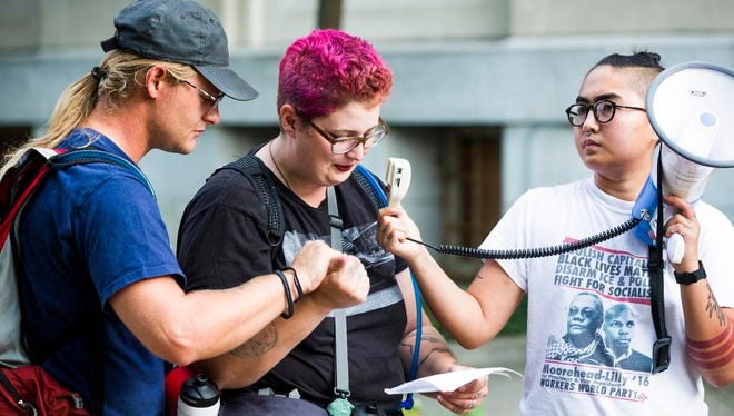 August, left, and Pages, share their experience as street medics during the violent protests in Charlottesville, Va., during a rally in front of a Confederate statue Monday, Aug. 14, 2017, in Durham, N.C. Protesters in North Carolina toppled the nearly century-old statue of a Confederate soldier Monday at the rally against racism. The Durham protest was in response to a white nationalist rally held in Charlottesville, Va., over the weekend. (Casey Toth/The Herald-Sun via AP)