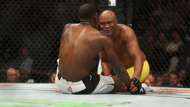 Anderson Silva (red gloves) shares a smile with Derek Brunson (blue gloves) moments after their fight during UFC 208 at Barclays Center.