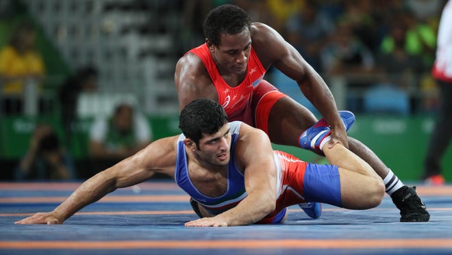 Aug 20, 2016; Rio de J'den Michael Tbory Cox of the United States, top, faces Alirez Mohammad Karimimachiani of Iran in men's freestyle wrestling competition during the Rio 2016 Summer Olympic Games at Carioca Arena 2.