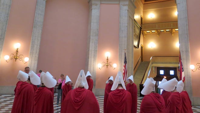 On June 13, women dressed in character from the dystopian novel "The Handmaid's Tale" stage a protest in the Ohio Statehouse Rotunda.