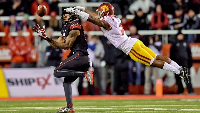Utah wide receiver Tim Patrick (12) catches a pass as USC defensive back Adoree' Jackson (2) dives for the tackle.