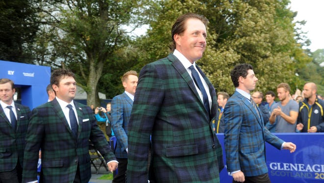 Phil Mickelson, front left, walks alongside European golfer Rory McIlroy  during the opening ceremony for the 2014 Ryder Cup at The Gleneagles Hotel.