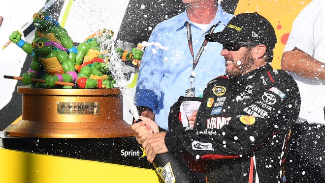 Martin Truex Jr. (78) celebrates after winning Sunday's Teenage Mutant Ninja Turtles 400 at Chicagoland Speedway and clinching a berth in the second round of the Chase for the Sprint Cup.