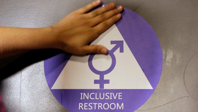 In this May 17, 2016 file photo, a new sticker is placed on the door at the ceremonial opening of a gender neutral bathroom at Nathan Hale High School in Seattle.