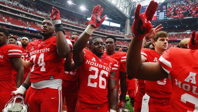 Brandon Wilson (26), who made the play that broke open Houston's victory against Oklahoma on Saturday, waves to fans with teammates.