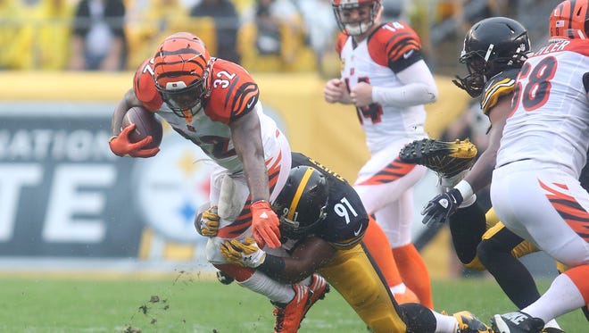 Steelers defender Stephon Tuitt (91) brings down Bengals running back Jeremy Hill (32) after a first-half carry.