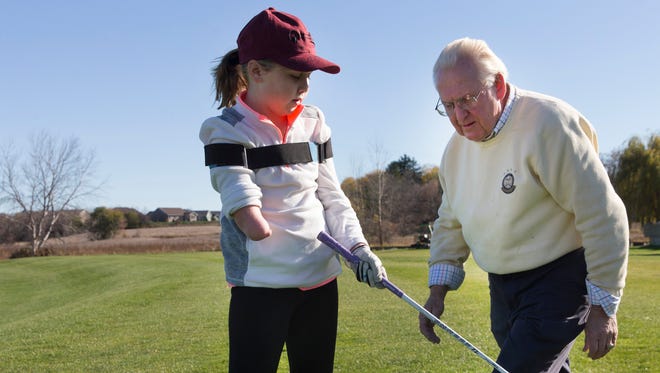 Audrey Crowley, 9, born with a right arm that ends at the elbow, takes golf lessons with PGA professional Bob Burns at the Bob Burns Golf Company and Academy in Appleton.