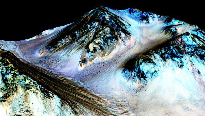 This undated photo provided by NASA and taken by an instrument aboard the agency's Mars Reconnaissance Orbiter shows dark, narrow, 100 meter-long streaks on the surface of Mars that scientists believe were caused by flowing streams of salty water. Researchers said Monday, Sept. 28, 2015, that the latest observations strongly support the longtime theory that salt water in liquid form flows down certain Martian slopes each summer.