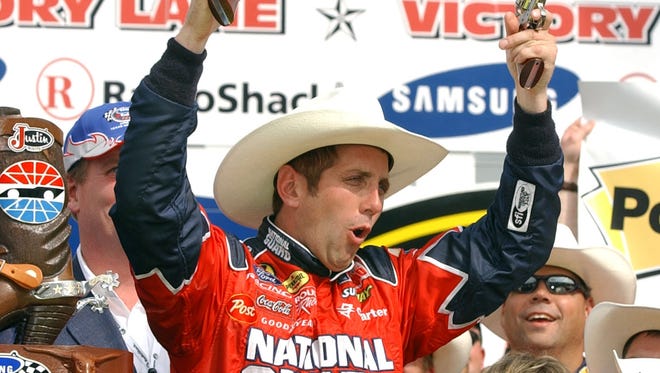 Greg Biffle celebrates his win in the Samsung/RadioShack 500 NASCAR race with a pair of six-shooters in victory lane at the Texas Motor Speedway in 2005.