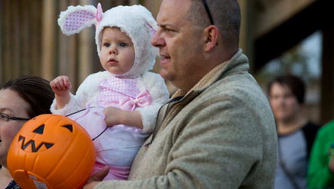 Jason Back of Des Moines, carries his 18-month-old daughter Bailee while trick-or-treating during Night Eyes at Blank Park Zoo in Des Moines, Iowa, Thursday, Oct. 15, 2015.