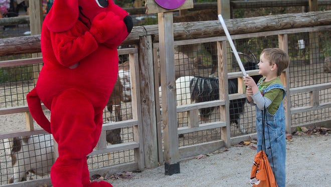 Liam Mahoney, 4, of Des Moines, meets Clifford the Big Red Dog while trick-or-treating during Night Eyes at Blank Park Zoo in Des Moines, Iowa, Thursday, Oct. 15, 2015.
