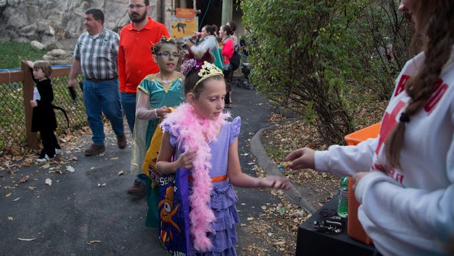 Kimberly Painter, 8, of Perry, gathers candy with her sister Clarissa, 10, while trick-or-treating during Night Eyes at Blank Park Zoo in Des Moines, Iowa, Thursday, Oct. 15, 2015. Kimberly was dressed as Fancy Nancy and Clarissa was Medusa.