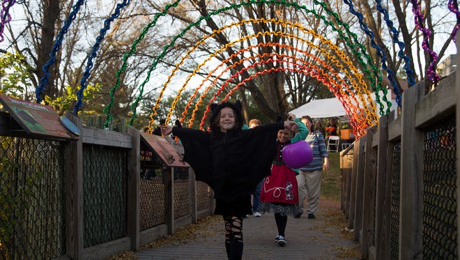 Jessica Thorn, 8, of Des Moines, flaps her bat wings with her sister Emily, 10, as they trick-or-treat during Night Eyes at Blank Park Zoo in Des Moines, Iowa, Thursday, Oct. 15, 2015.