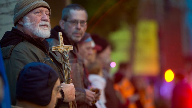 Herb Schneider, a member of St. Mary's Catholic Church, held a crucifix and prayed the rosary with others on the sidewalk in front of the EMW Women's Surgical Center, the last abortion clinic in Kentucky. Feb. 11, 2017. By Pat McDonogh, The CJ