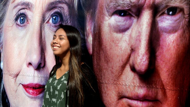 Hofstra University student Gianna Rojas, 19, has her photo taken between images of the two candidates ahead of the first presidential debate between Hillary Clinton and Donald Trump at Hofstra University.