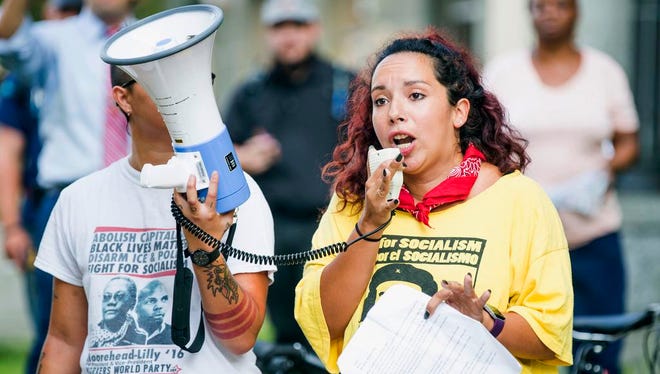 Alissa Ellis speaks to a crowd of protesters gathered in front of a Confederate statue at the old Durham County Courthouse, Monday, Aug. 14, 2017, in Durham, N.C. Protesters in North Carolina toppled a nearly century-old statue of a Confederate soldier Monday at the rally against racism. The Durham protest was in response to a white nationalist rally held in Charlottesville, Va., over the weekend. (Casey Toth/The Herald-Sun via AP)