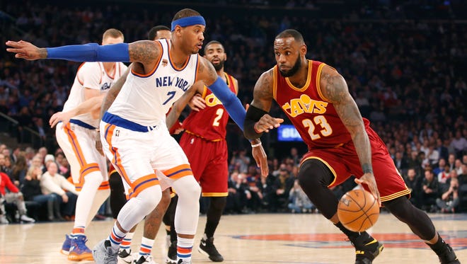Cleveland Cavaliers forward LeBron James driving to the basket with Carmelo Anthony defending, following Phil Jackson's comments about James and his "posse".