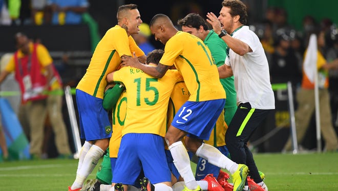 Brazil forward Neymar (10) celebrates with teammates after his game-winning penalty kick goal against Germany in the men's gold medal match during the Rio 2016 Summer Olympic Games at Maracana.