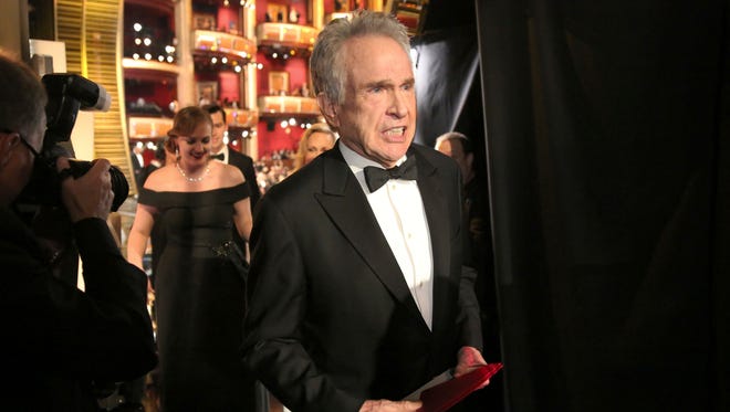 Warren Beatty exits the stage after announcing the award for best picture at the Oscars.