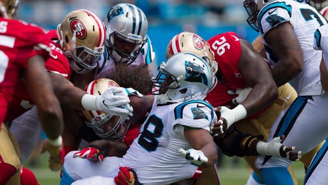 Panthers running back Jonathan Stewart (28) gets stopped by a trio of 49ers defenders on a first-half carry.