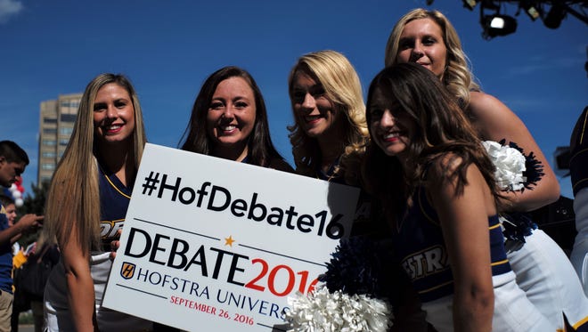 Cheerleaders pose with a sign before the debate.