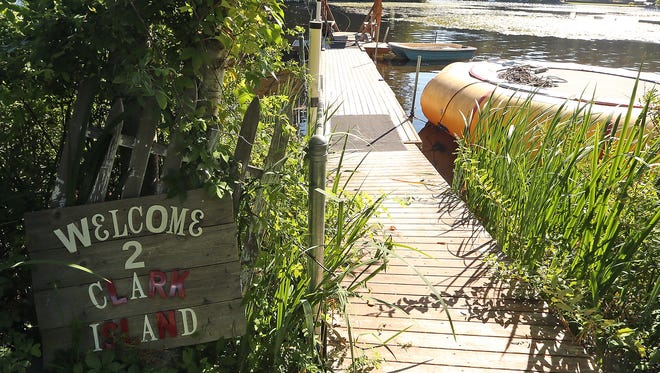 A welcome sign greets visitors to the dock where the small "ferry" awaits on the shore of Island Lake.