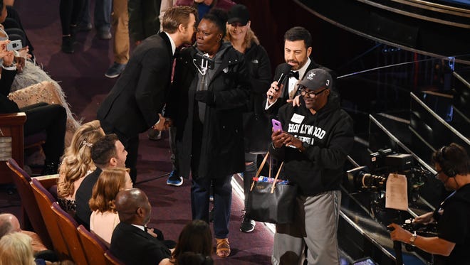 Ryan Gosling greets a member of a group of tourists from a sight seeing tour brought into the theatre during the 89th Academy Awards.