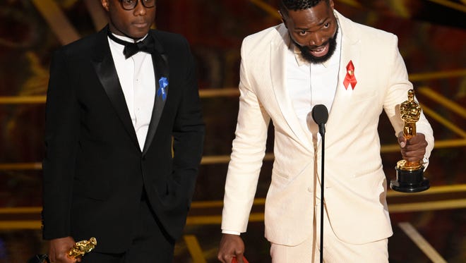 Barry Jenkins, left, and Tarell Alvin McCraney accept the award for best adapted screenplay for 'Moonlight' at the Oscars on Sunday.