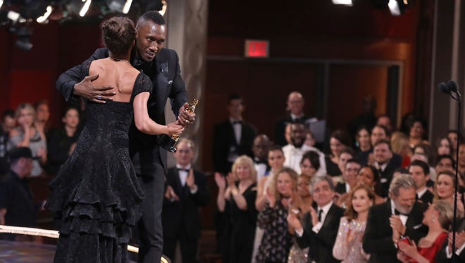 Alicia Vikander, left, presents the award for best actor in a supporting role to Mahershala Ali for "Moonlight" at the Oscars in Los Angeles.