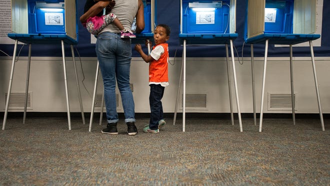 Gavin Edwards, 5, waits patiently as his great-aunt, Lorrie Witherspoon, fills out her ballot at the Durham County Main Library in Durham, N.C., on March 15, 2016.