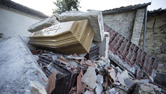 Two coffins are seen among the rubble.
