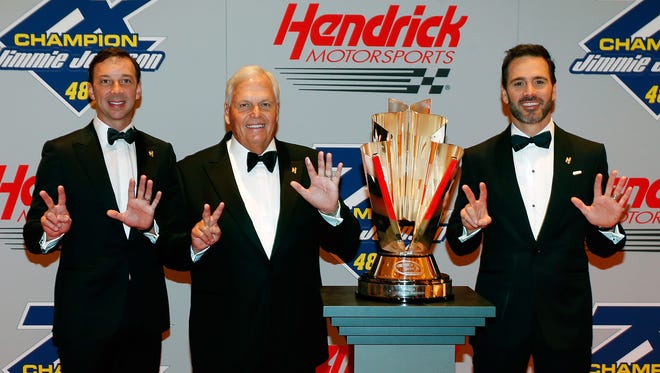 (From left to right) Crew chief Chad Knaus, team owner Rick Hendrick and driver Jimmie Johnson pose with the championship trophy.