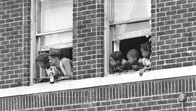 People look out of the window during the Detroit Riots in July 1967.