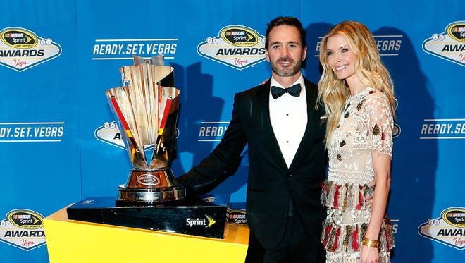 Jimmie Johnson and his wife Chandra pose with the 2016 NASCAR Sprint Cup championship trophy.